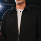 Man wearing a black coat with a blurred background