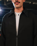 Man wearing a black coat with a blurred background