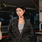 Woman wearing a textured black coat in an indoor setting
