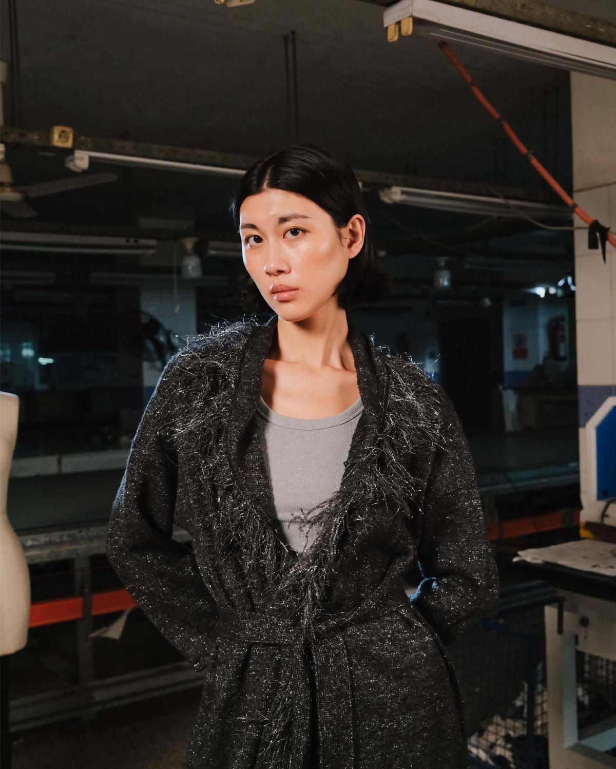 Woman wearing a textured black coat in an indoor setting