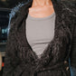Person wearing a dark gray textured cardigan over a gray shirt.
