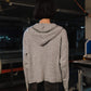 Person wearing a striped hoodie in an industrial setting