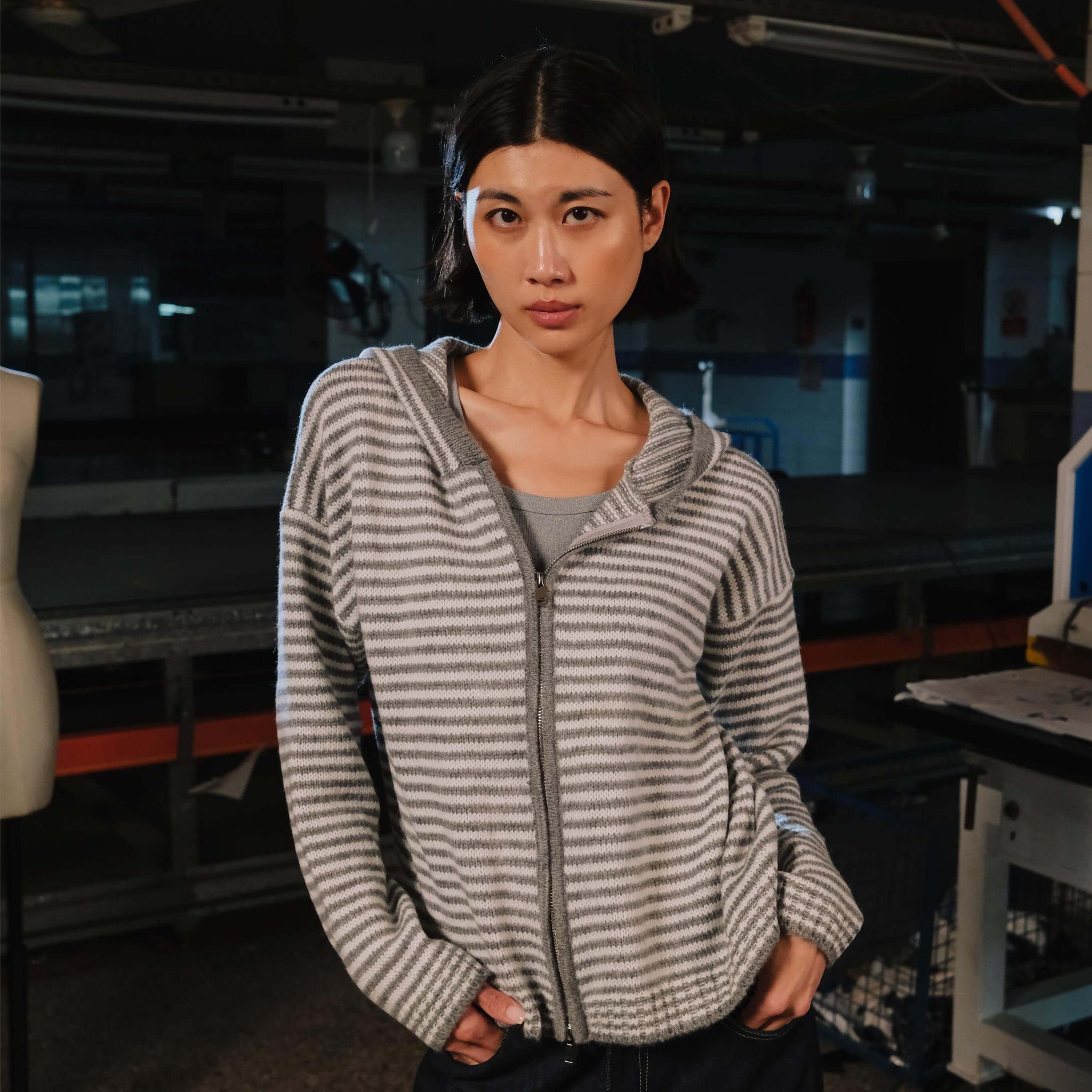 Woman wearing a striped hoodie in an indoor setting
