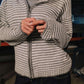 Person wearing a striped hoodie with a blurred background