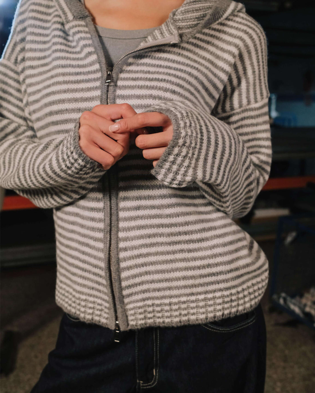 Woman wearing a striped hoodie in an indoor setting