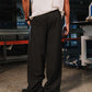 Person wearing a white shirt and black pinstripe pants in an industrial setting