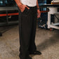 Person wearing black pinstripe pants standing in an industrial setting