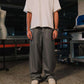 Person wearing a white shirt and gray striped pants in an industrial setting