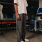 Person wearing a white t-shirt and gray striped pants in an indoor setting