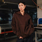Person wearing a brown hoodie in an industrial setting