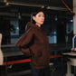Person wearing a brown hoodie in an industrial setting