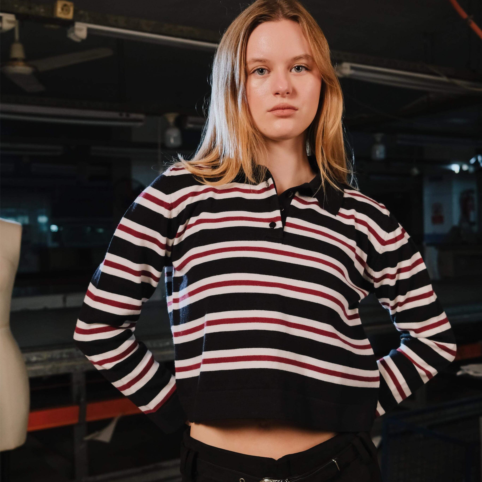 Person wearing a black, red, and white striped hoodie in an indoor setting