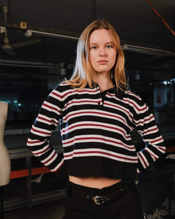 Person wearing a black, red, and white striped hoodie in an indoor setting