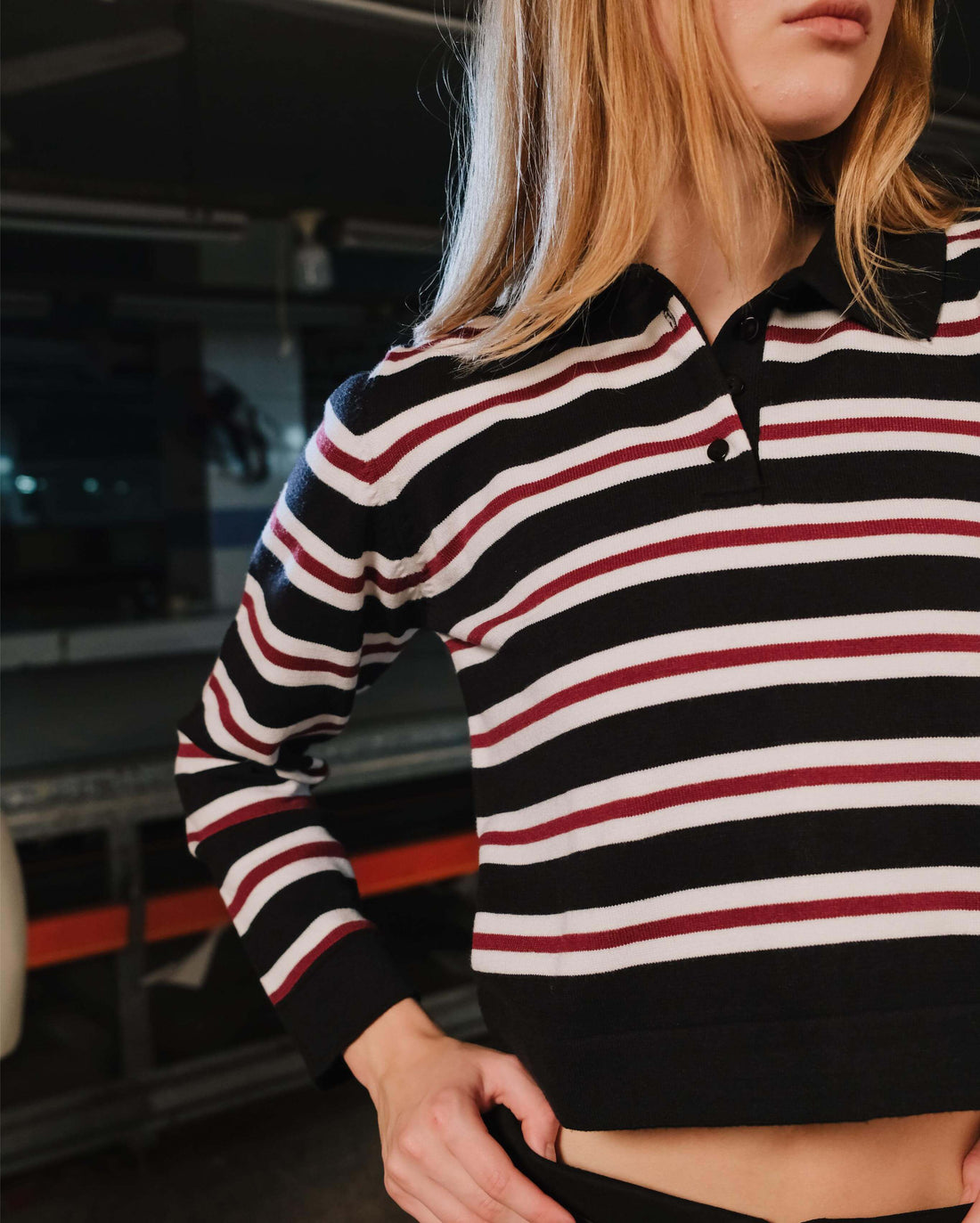 Person wearing a black, red, and white striped hoodie in an indoor setting