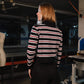 Person wearing a black, white, and red striped shirt in an indoor setting