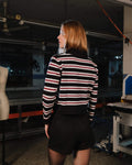 Person wearing a black, white, and red striped shirt in an indoor setting