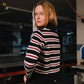 Person wearing a black and white striped sweater in an indoor setting