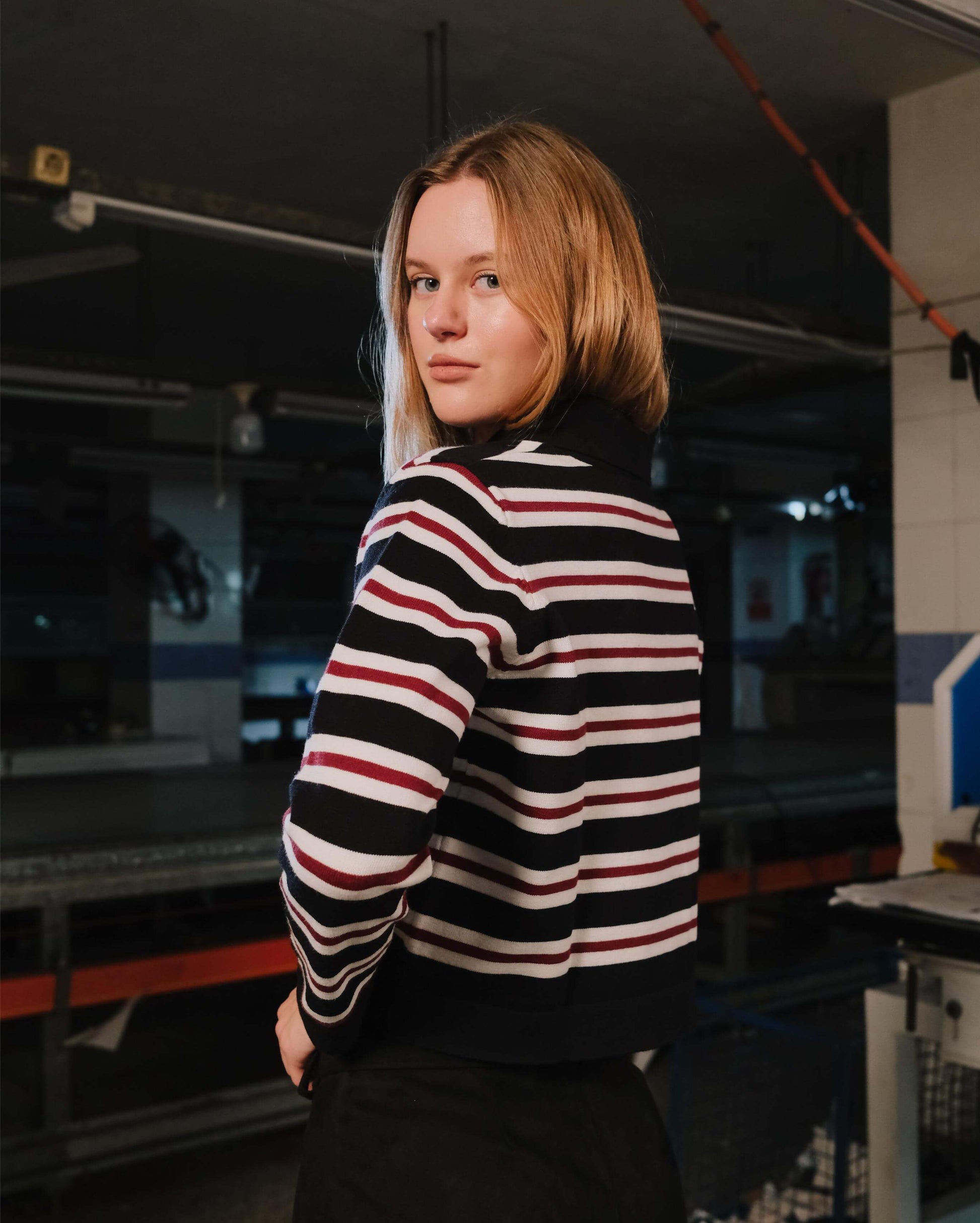 Person wearing a black and white striped sweater in an indoor setting