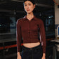Person wearing a brown shirt and dark jeans in an industrial setting