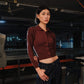 Person wearing a maroon shirt and dark pants in an industrial setting