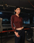 Person wearing a maroon shirt and dark pants in an industrial setting