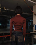 Person wearing a red shirt and dark pants in a garage setting