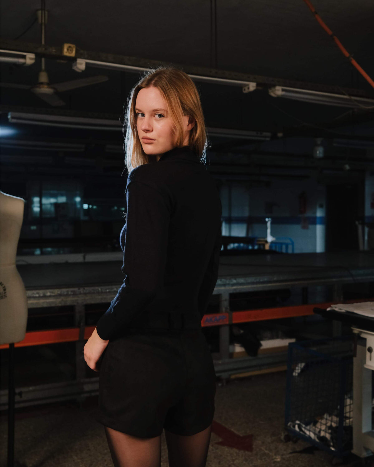 Person wearing a black outfit in an industrial setting