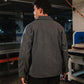 Person wearing a gray jacket in an industrial setting