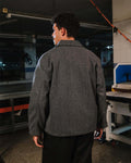 Person wearing a gray jacket in an industrial setting