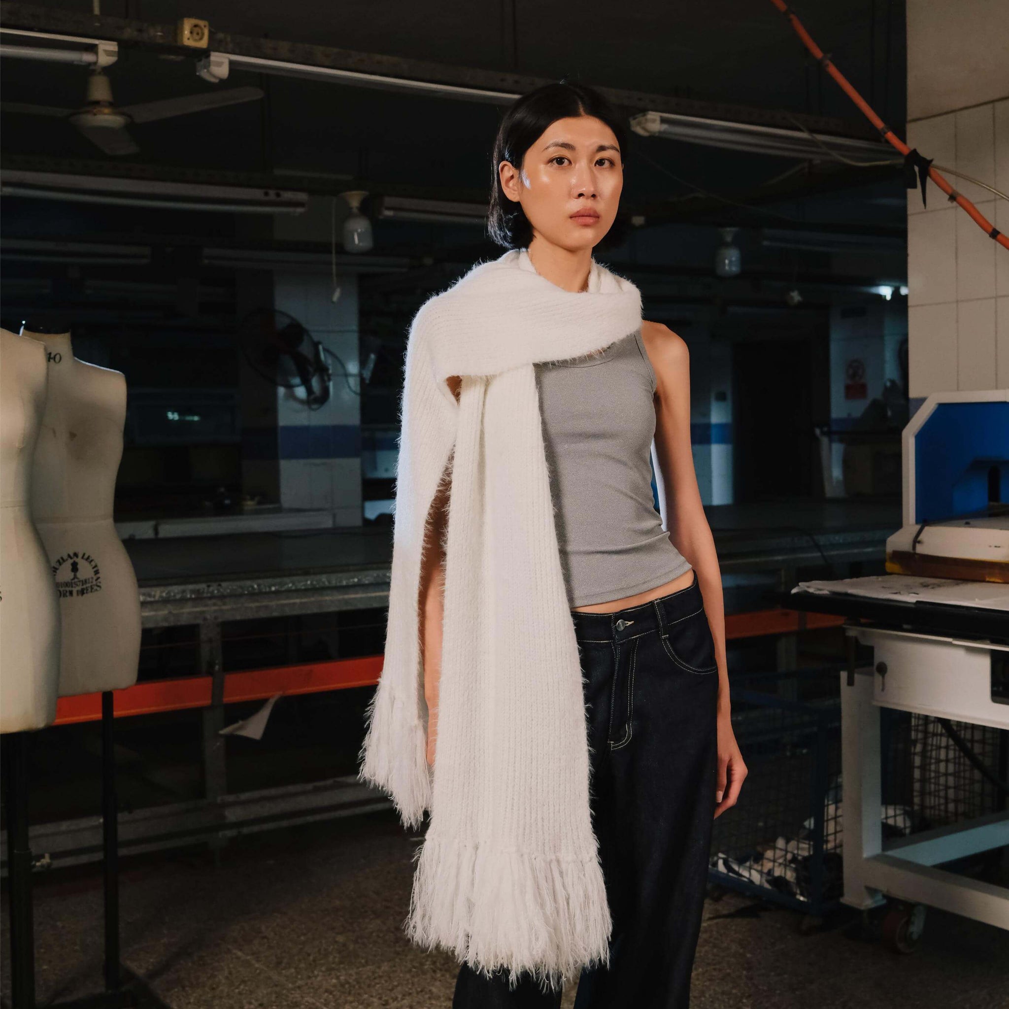 Person wearing a white scarf in an industrial setting