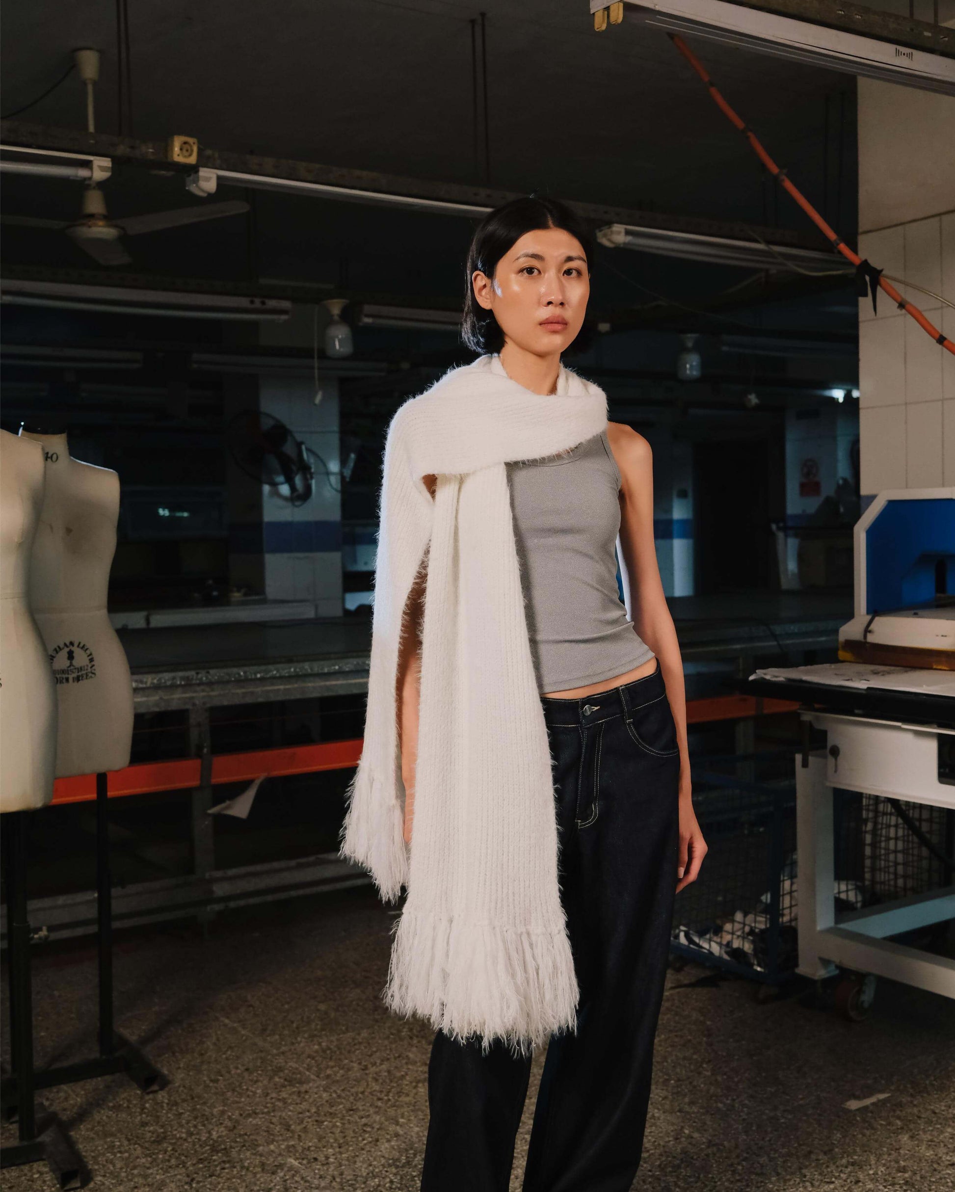 Person wearing a white scarf in an industrial setting