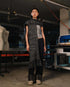 Person wearing a textured scarf and pants in an industrial setting