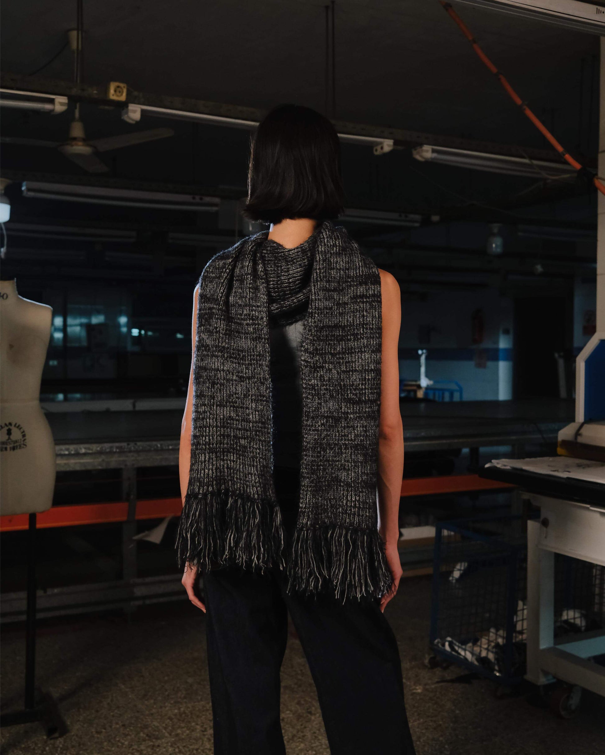 Person wearing a black and gray scarf in an indoor setting