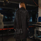 Person wearing a dark coat with sequin details in an indoor setting