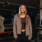 Person wearing a striped sweater in an indoor setting with equipment and a mannequin in the background