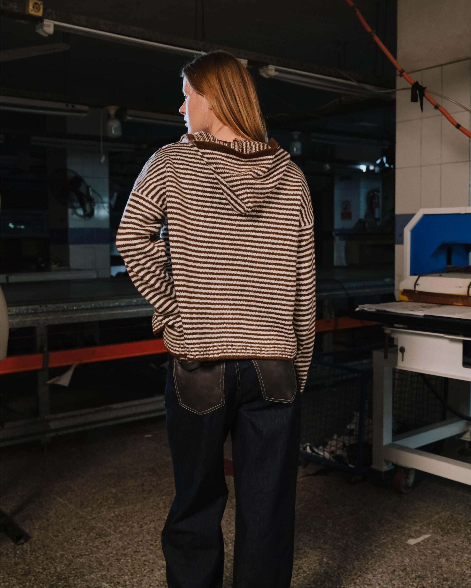 Person wearing a striped jacket in a workshop setting