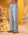 a man wearing a white tee and blue and white checkered lounge pants