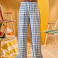 a man wearing a white tee and blue and white checkered lounge pants