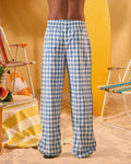 a man wearing a white tee and blue and white checkered lounge pants
