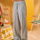 a man wearing a white tee and grey and white checkered lounge pants