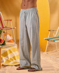 a man wearing a white tee and grey and white checkered lounge pants