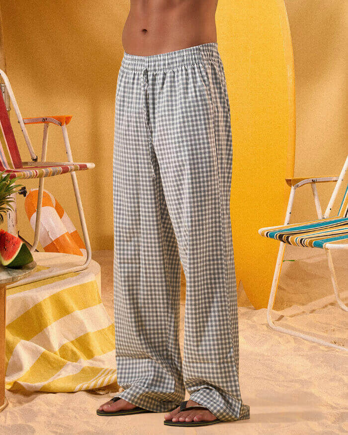 a man wearing a white tee and grey and white checkered lounge pants