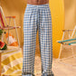 a man wearing a white tee and blue and white checkered lounge pants