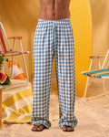 a man wearing a white tee and blue and white checkered lounge pants