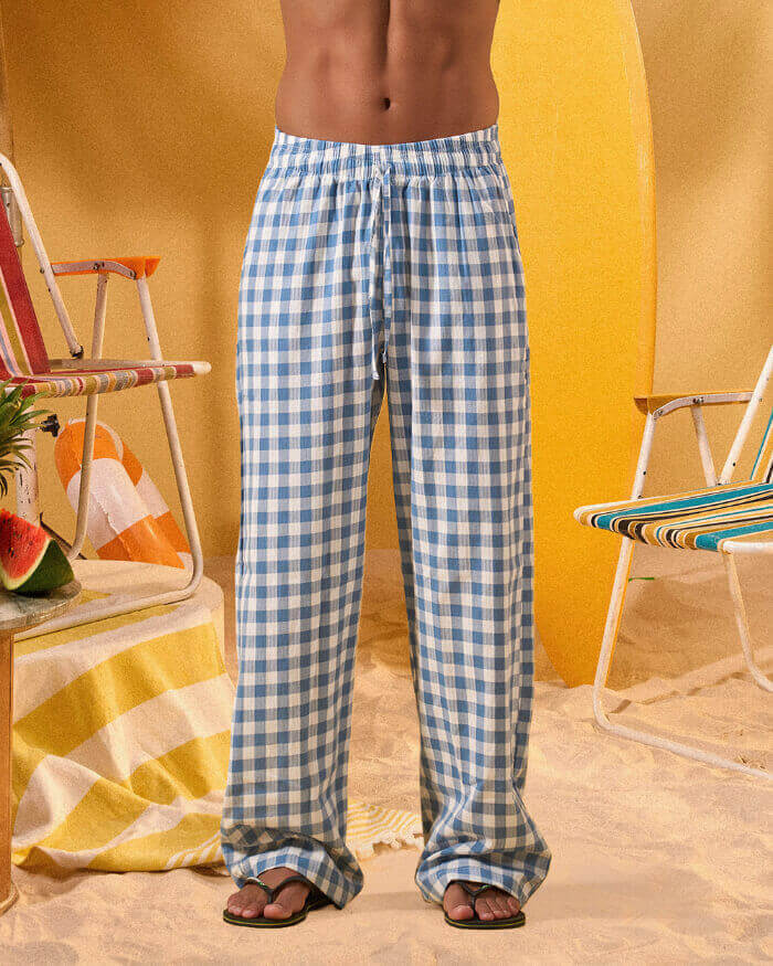 a man wearing a white tee and blue and white checkered lounge pants