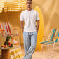 a man wearing a white tee and blue and white checkered lounge pants