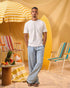 a man wearing a white tee and blue and white checkered lounge pants