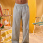a man wearing a white tee and grey and white checkered lounge pants