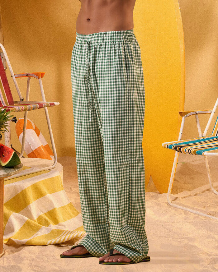 a man wearing a white tee and green and white checkered lounge pants