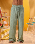 a man wearing a white tee and green and white checkered lounge pants